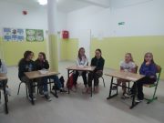 grupa dzieci siedzących przy biurkach w klasie